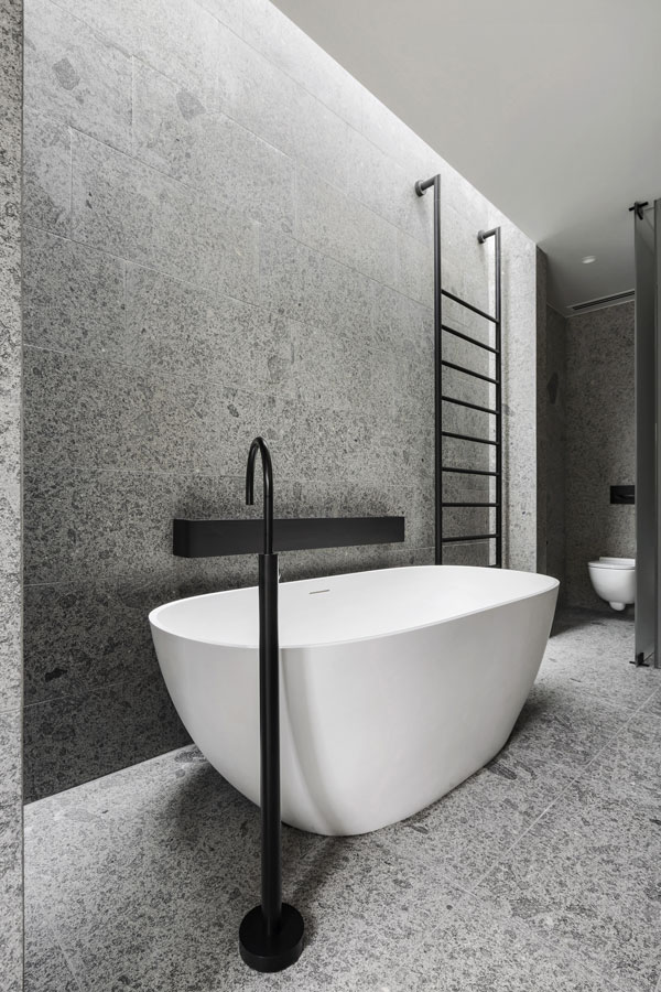 Minimalist bathroom tile featuring monochrome pattern and sleek black fittings.